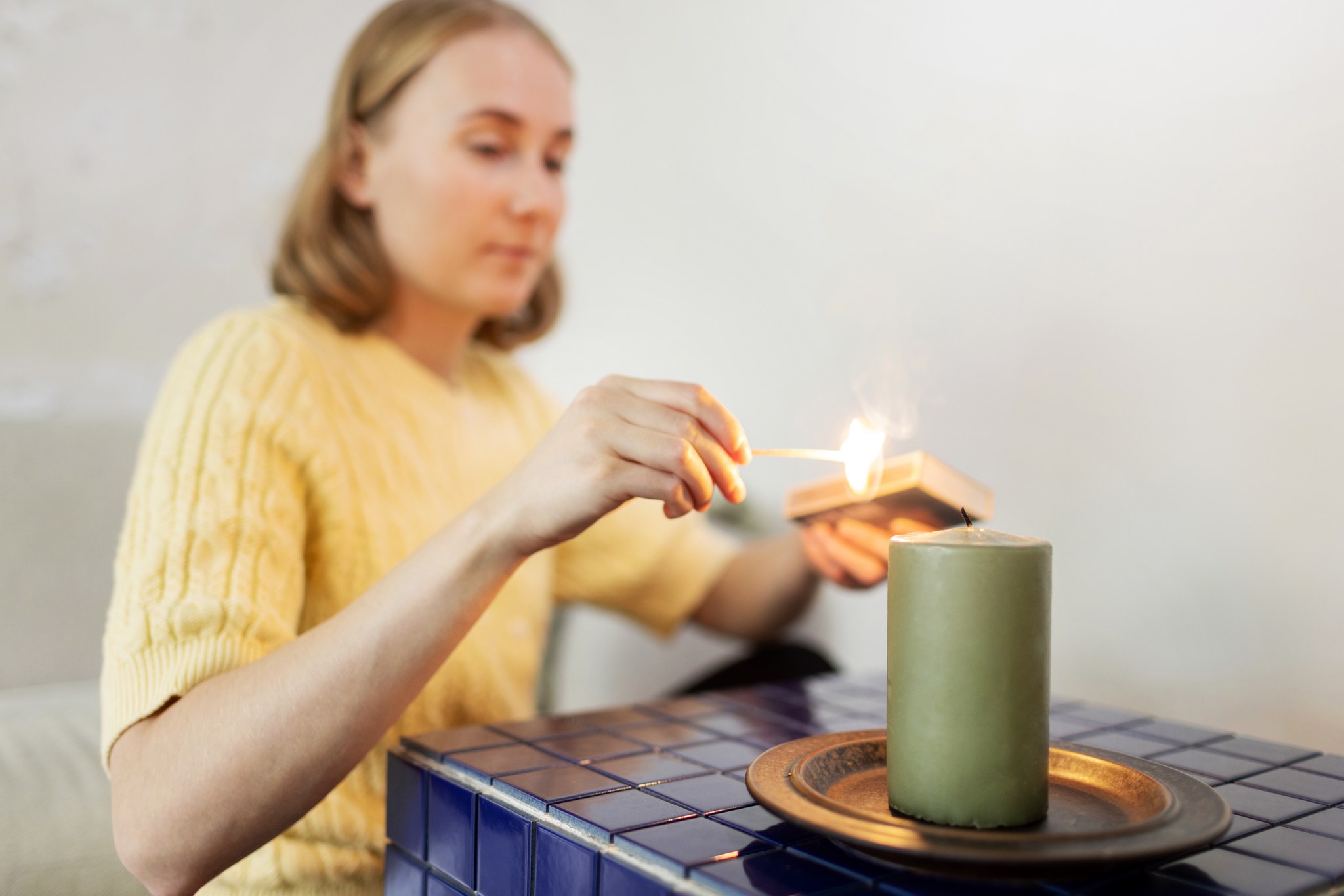 A person lights a candle with a match.